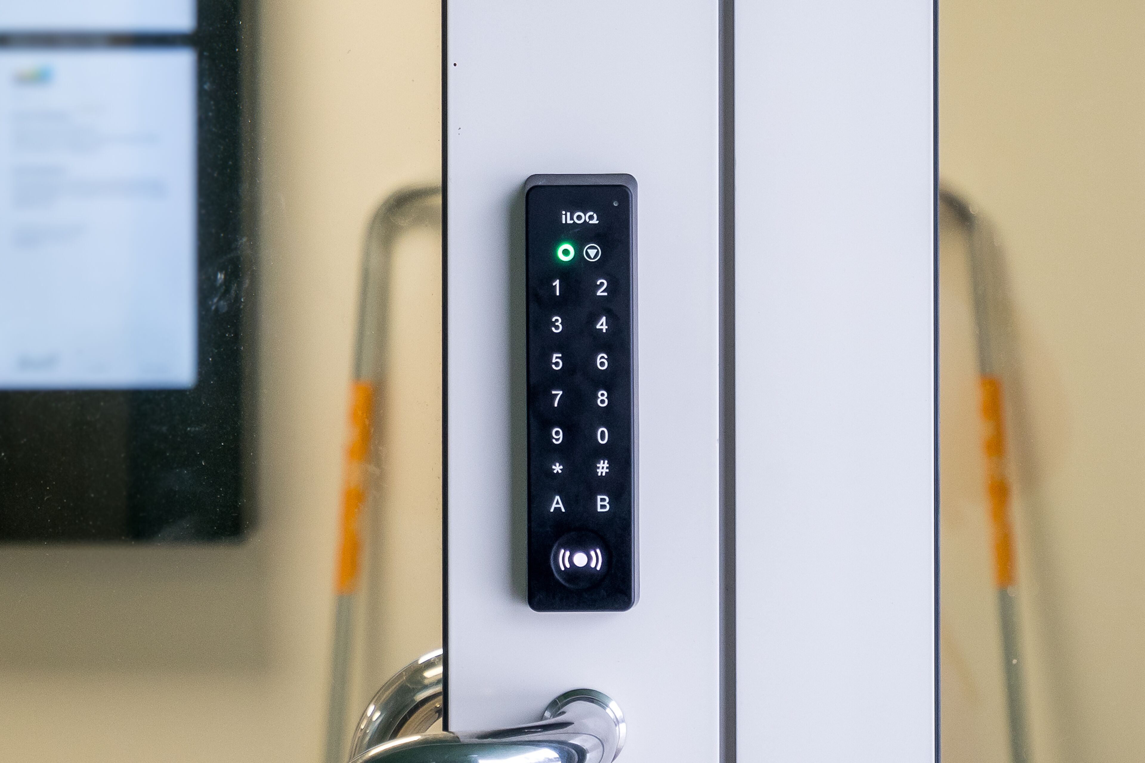 A digital keypad lock on a door, with a screen displaying a list of items on the left.