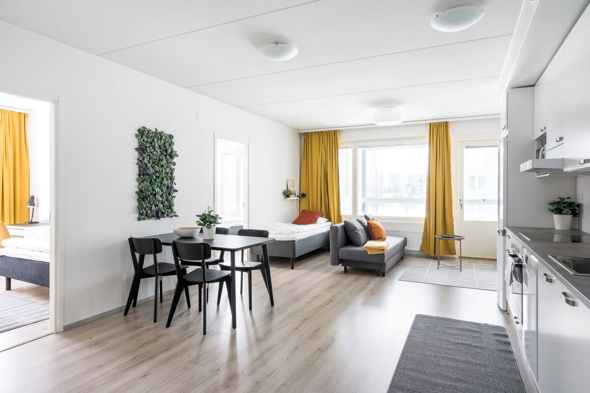 Un appartement moderne comprenant un coin repas, un canapé, une cuisine et offrant une vue sur la ville.