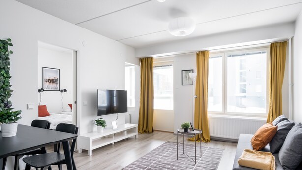 Moderni olohuone, jossa on litteänäyttöinen televisio, sohva, ruokapöytä tuoleineen ja ruukkukasvi.