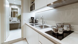 A modern kitchen with a built-in stove, a sink, and a coffee maker.