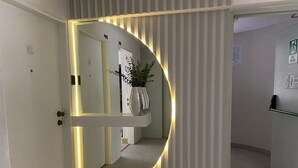 Ein Flur mit einer gewölbten Wand und einer Pflanze im Blumentopf.