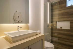 A modern bathroom with a large rectangular sink, a mirror, and a glass-enclosed shower area. - w* | Amazing 2BR near Malecon in Miraflores (Miraflores)