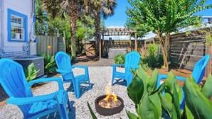 A patio with blue chairs, a fire pit, and a pergola. - Marvelous Mermaid Beach Bungalow, Dog-Friendly (St. Augustine)