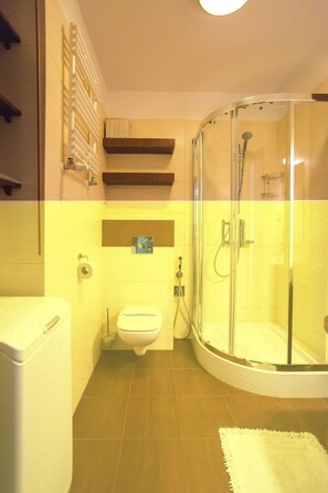 Une salle de bain avec une douche à parois de verre, des toilettes et un lavabo.
