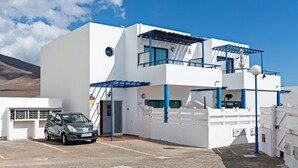 A modern white building with a car parked in front. - 3BR Home - Private Heated Pool - Parking (Playa Blanca)