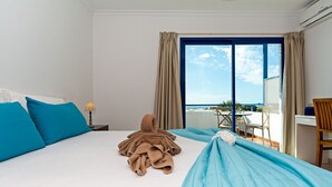 A hotel room with a bed, a desk, and a view of the ocean. - 3BR Home - Private Heated Pool - Parking (Playa Blanca)