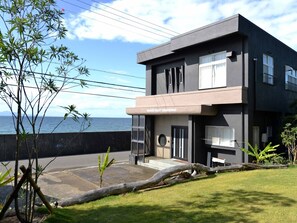 A modern two-story building with a flat roof, large windows, and a sign reading "Saside Resort Minamiwaju."