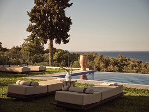 Utendørsbasseng, et evighetsbasseng og solsenger