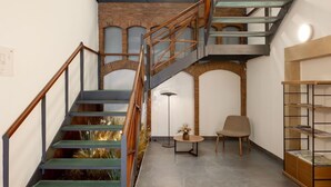 A multi-level interior with a staircase, a seating area, and a shelving unit. - EtxeAundi Hotel Boutique (Oñati)