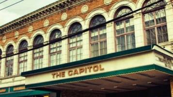 A building with a sign reading "THE CAPITOL" on the facade.
