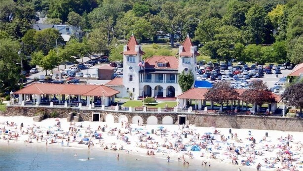 A coastal hotel with a large beach area, multiple buildings, and a parking lot. - Flex Comfort Apts of Westchester #2 (Rye Brook)