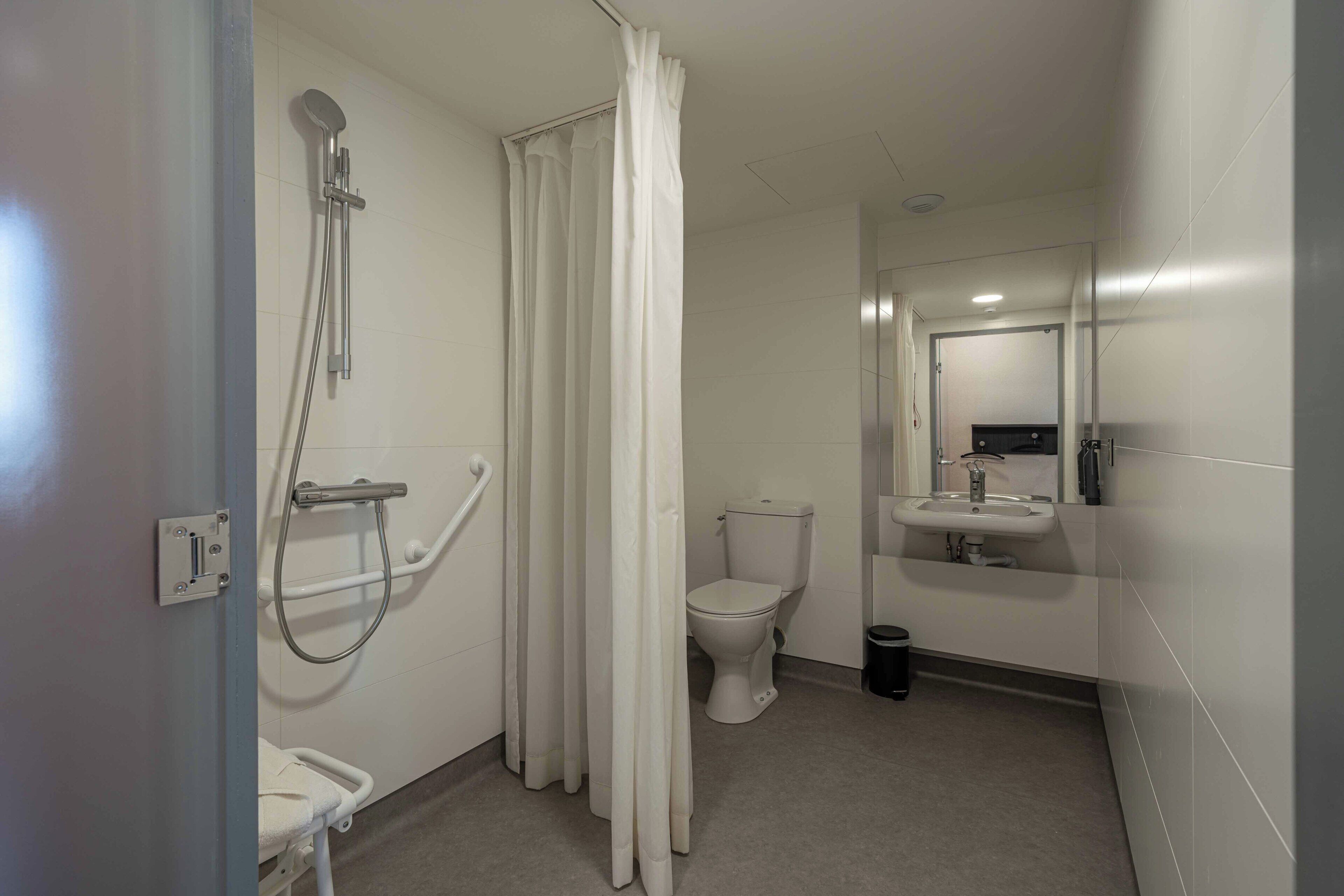 A bathroom with a shower, toilet, and sink.
