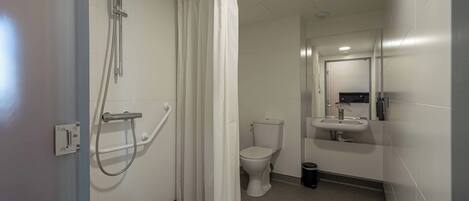 A bathroom with a shower, toilet, and sink.