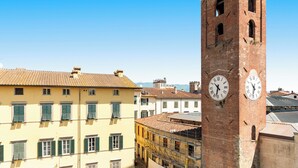 Una torre de reloj histórica con diseño tradicional, rodeada de arquitectura europea clásica.