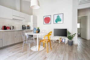 Una cucina moderna con zona pranzo, TV e una pianta in vaso.