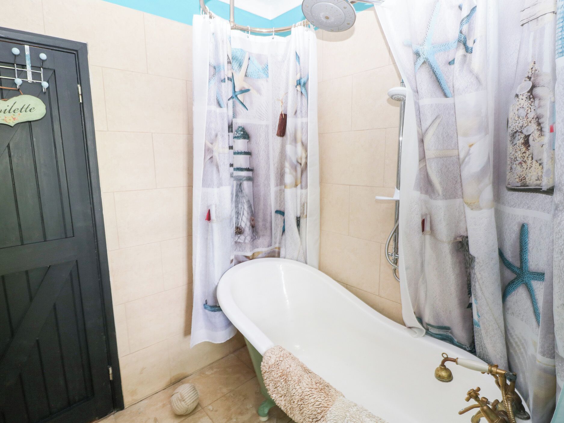 Un baño con bañera, ducha y una puerta con un letrero.