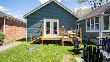 A small, single-story house with a wooden deck and a front door.