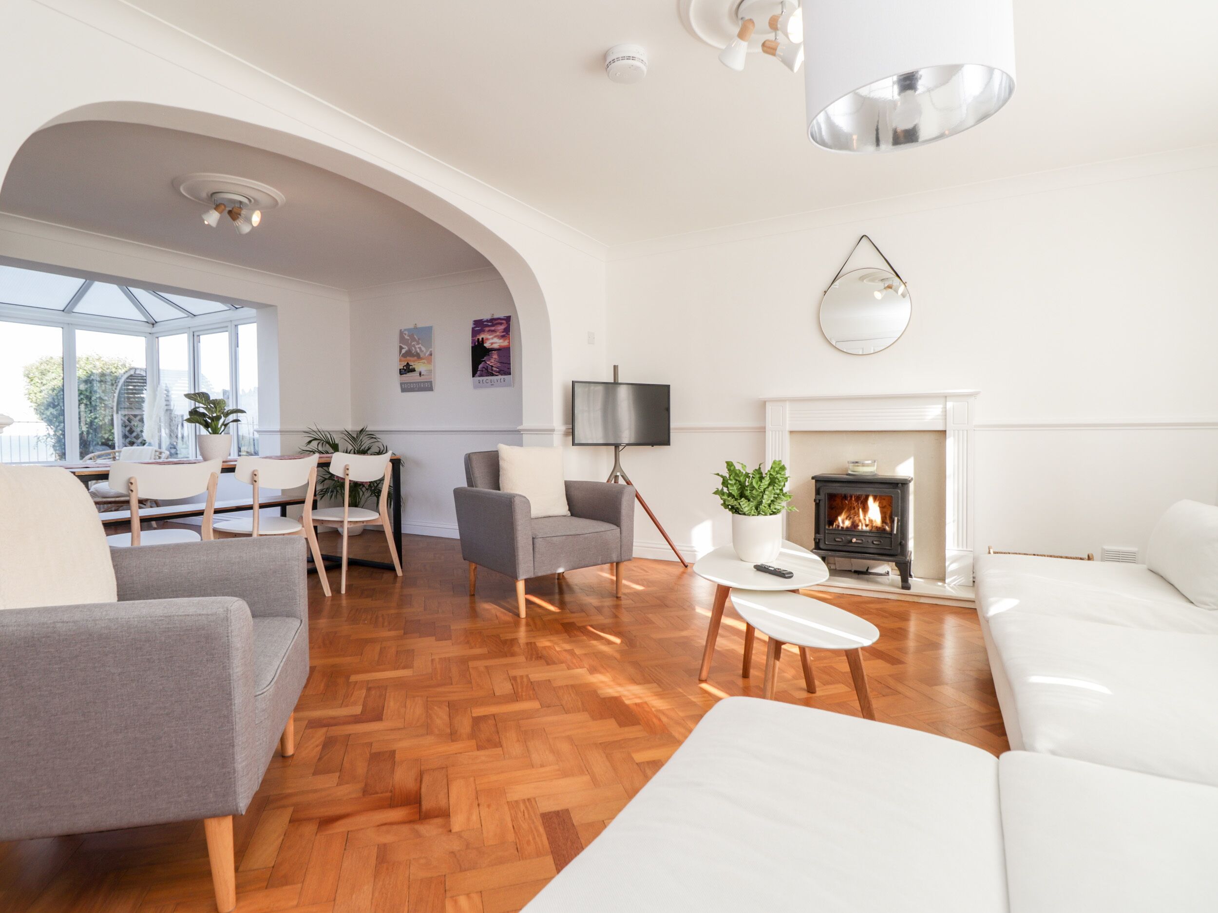 A spacious living room with a fireplace, a dining area, and a seating area with sofas and chairs.