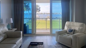 Un salón moderno con vista a un puerto deportivo y una zona verde.