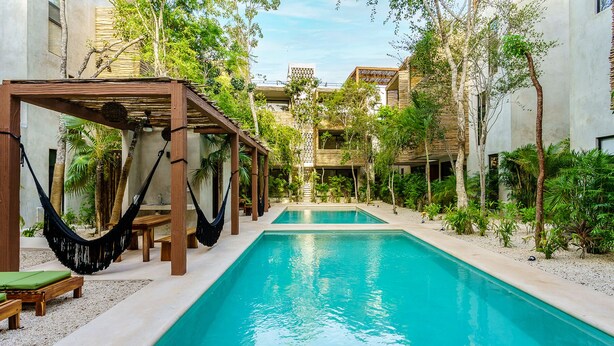 A pool area with a wooden pergola, hammocks, and lounge chairs. - Eco-sustainable Luxury Between Beach Hotspots & Tulum Town by Stella Rentals (Tulum)