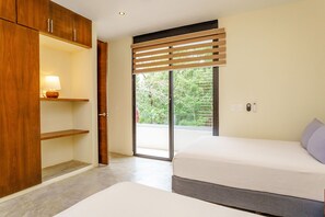 A bedroom with a bed, a wooden wardrobe, a lamp, and a sliding glass door leading to a balcony. - Magazine-worthy Villa Ponderosa with Private Pool & Gated Area (Tulum)