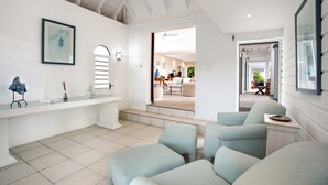 Un amplio salón con techo alto, un ventanal y vista al comedor.