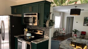 A kitchen with dark green cabinets, stainless steel appliances, and a marble countertop. - Stylish - Minutes From Beach, Bars & Eateries (West Palm Beach)