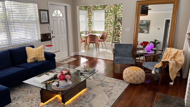 A modern living room with a blue sofa, a glass coffee table, and a patterned rug. - Stylish - Minutes From Beach, Bars & Eateries (West Palm Beach)