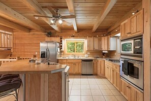 Enjoy cooking in this well-equipped kitchen with a central island, sink, and stainless steel appliances.