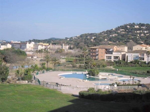 Zona residencial con piscina, casas y un paisaje montañoso al fondo.