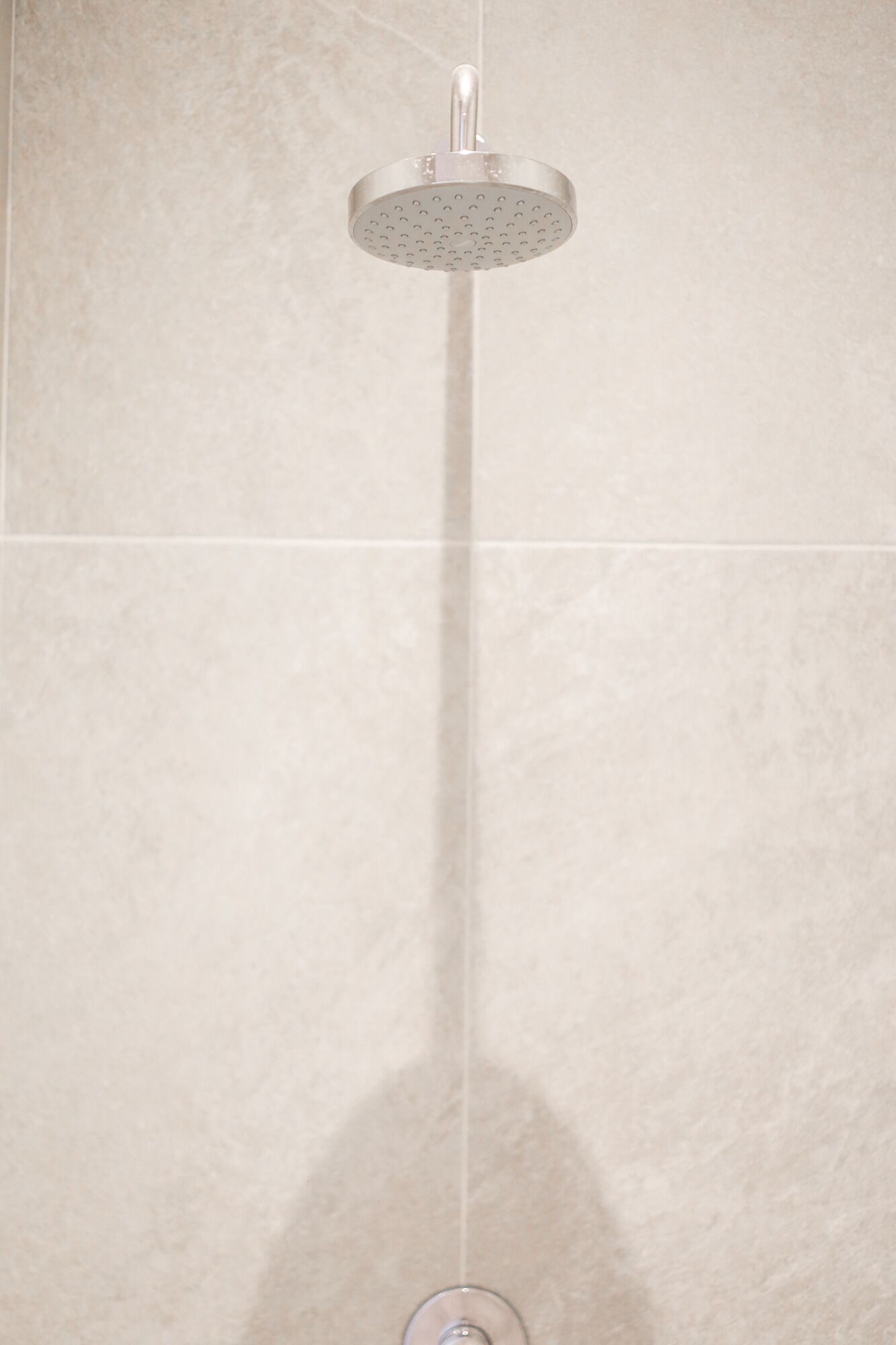 A showerhead mounted on a tiled wall.
