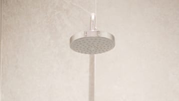 Un cabezal de ducha instalado en una pared de azulejos.