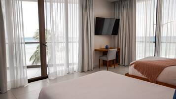A hotel room with a bed, a desk, a chair, and a TV.