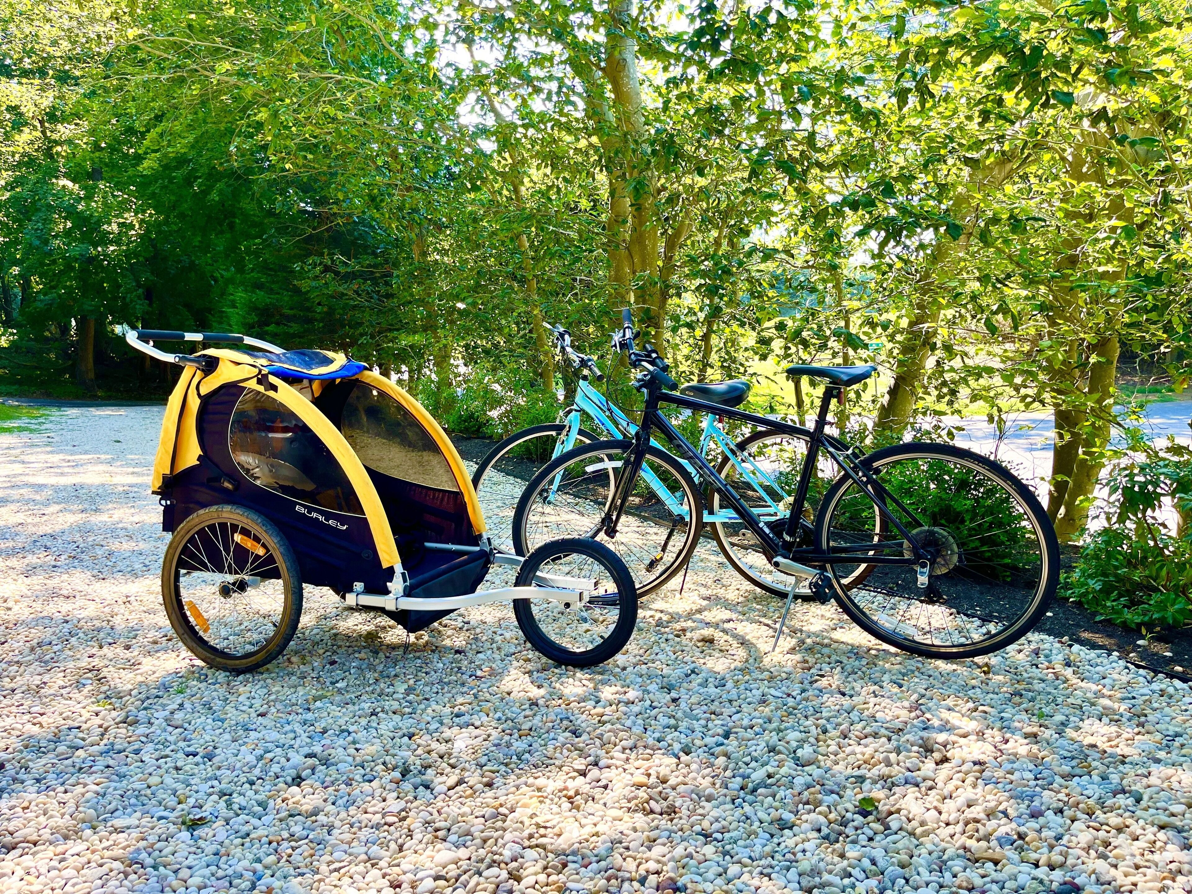 Un vélo équipé d’un siège enfant, garé sur un chemin de gravier.