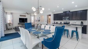A modern kitchen with dark cabinets, a microwave, and a stove. - Luxury Private Villa with Pool on Solara Resort, Orlando Villa 5587 (Orlando)