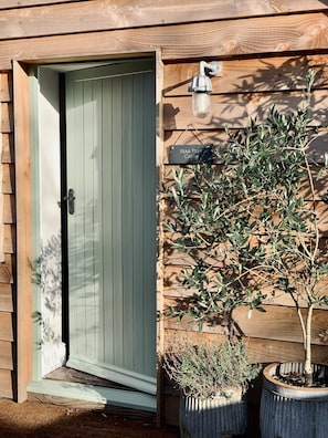 Welcome to the charming Pear Tree Cabin, featuring a cozy atmosphere and lush greenery.