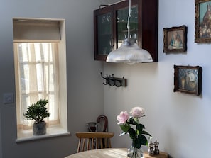 Enjoy a stylish dining experience with a potted plant, vase, and framed artworks.