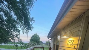 A wooden deck with a chair, a dog, and a house number 1733. - Pets, Families & Hunters Welcome  (Crofton)