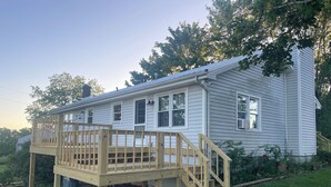 A single-story house with a wooden deck and stairs leading to the front door. - Pets, Families & Hunters Welcome  (Crofton)