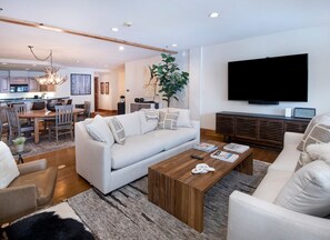 A modern living room with a sofa, coffee table, and a television. - Charlie Rentz: Ski-In/Out in Heart of Beaver Creek, Ice Rink Views, Walk Everywhere (Beaver Creek)