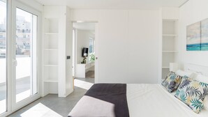 A bright bedroom with a bed, a large window, and a view of the city. - ☀️ ❤️ Watch Sunsets over the Rooftops at an Old Town Penthouse (Albufeira)