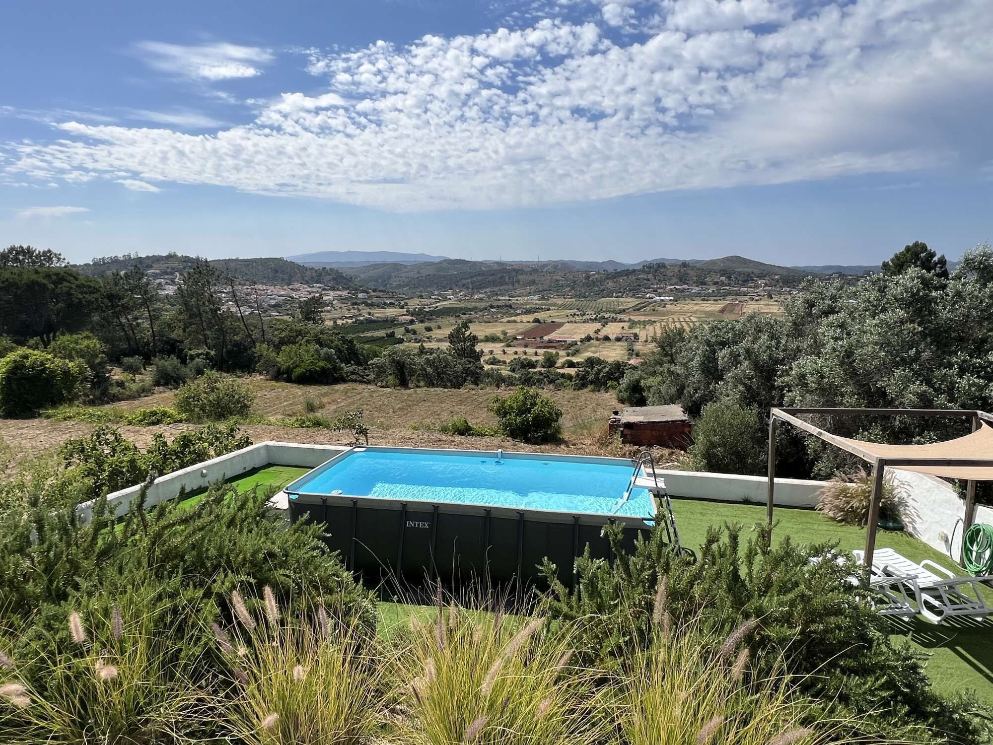 A swimming pool with a view of a rural landscape.
