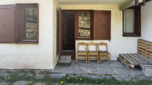A building with a balcony, a wooden bench, and a set of chairs. - La Lauzière-Dessus 27 - Divisible studio on the edge of the slopes, with a terrace facing south (LES AVANCHERS VALMOREL)