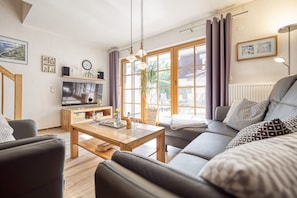 Een moderne woonkamer met een bank, salontafel en een televisie.