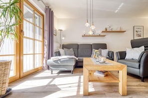 Een moderne woonkamer met een bank, een salontafel en een boekenkast.