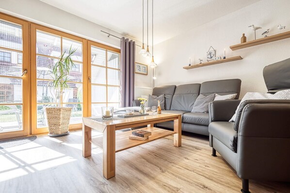Un salon moderne avec un canapé, une table basse et une plante en pot.