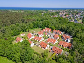 Vista aérea de una zona residencial con casas, espacios verdes y una costa.