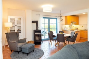 A living room with a fireplace, dining area, and kitchen.