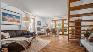 Ein modernes Wohnzimmer mit einer Ledersofa, einem Couchtisch und einem Essbereich mit Stühlen.