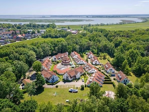 Luchtbeeld van een woongebied met huizen, een meer en een brug op de achtergrond.